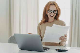 Femme enthousiaste lisant un document sur la comptabilité